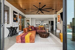 Un salon moderne avec un canapé d’angle, une table basse et un ventilateur de plafond.
