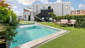 A modern residential building with a swimming pool, a staircase, and outdoor seating. - Brisamare Apt 5 | 2BR | Pool, BBQ, Generator (San Juan)