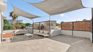 An outdoor patio with a sofa, chairs, and a table. - Brisamare Apt 5 | 2BR | Pool, BBQ, Generator (San Juan)