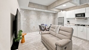 A modern kitchen with white cabinets, a built-in microwave, and a stainless steel refrigerator. - Brisamare Collection | Pool | Sleeps 14 (San Juan)