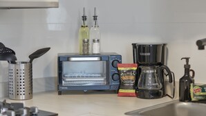 A kitchen with a microwave, toaster, coffee maker, and various kitchen utensils. - Brisamare Collection | Pool | Sleeps 14 (San Juan)