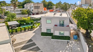 A modern residential building with a rooftop terrace, a swimming pool, and a well-maintained garden. - Brisamare Apt 2 | 2BR | Pool, BBQ, Generator (San Juan)