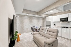 A modern kitchen with white cabinets, a built-in microwave, and a stainless steel refrigerator. - Brisamare Apt 2 | 2BR | Pool, BBQ, Generator (San Juan)