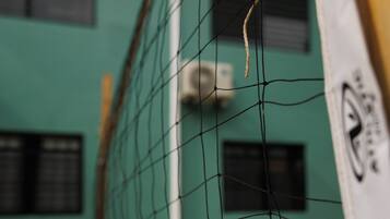 Ein Detailaufnahme eines Volleyballnetzes, im Hintergrund ein Gebäude.