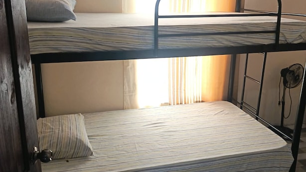 A bunk bed with a window and curtains, a wooden door, and a fan. - Villa Alomía, Private Pool, 10 People (Cahuita)