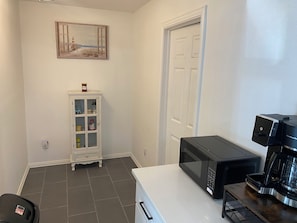 A kitchen with a microwave, coffee maker, and a cabinet with food items. - Spacious 4-bedroom Monthly Stay Cozy house with AC in terrific Arlington TX (Arlington)