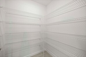 A corner of a room with multiple metal wire shelves. - Spacious 3BR · Sleeps 7 · King Bed · Lanai (Okahumpka)