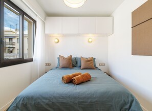 A bedroom with a bed, pillows, a window, and a wall-mounted light fixture. - Mamabaldi Apartment – Elegance, tranquility and views from the top of Nice (Nice)
