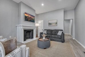 A living room with a fireplace, a grey sofa, and a coffee table. - Cleveland Clinic | Recliner | Relaxing | 3 Bedroom (Cleveland)