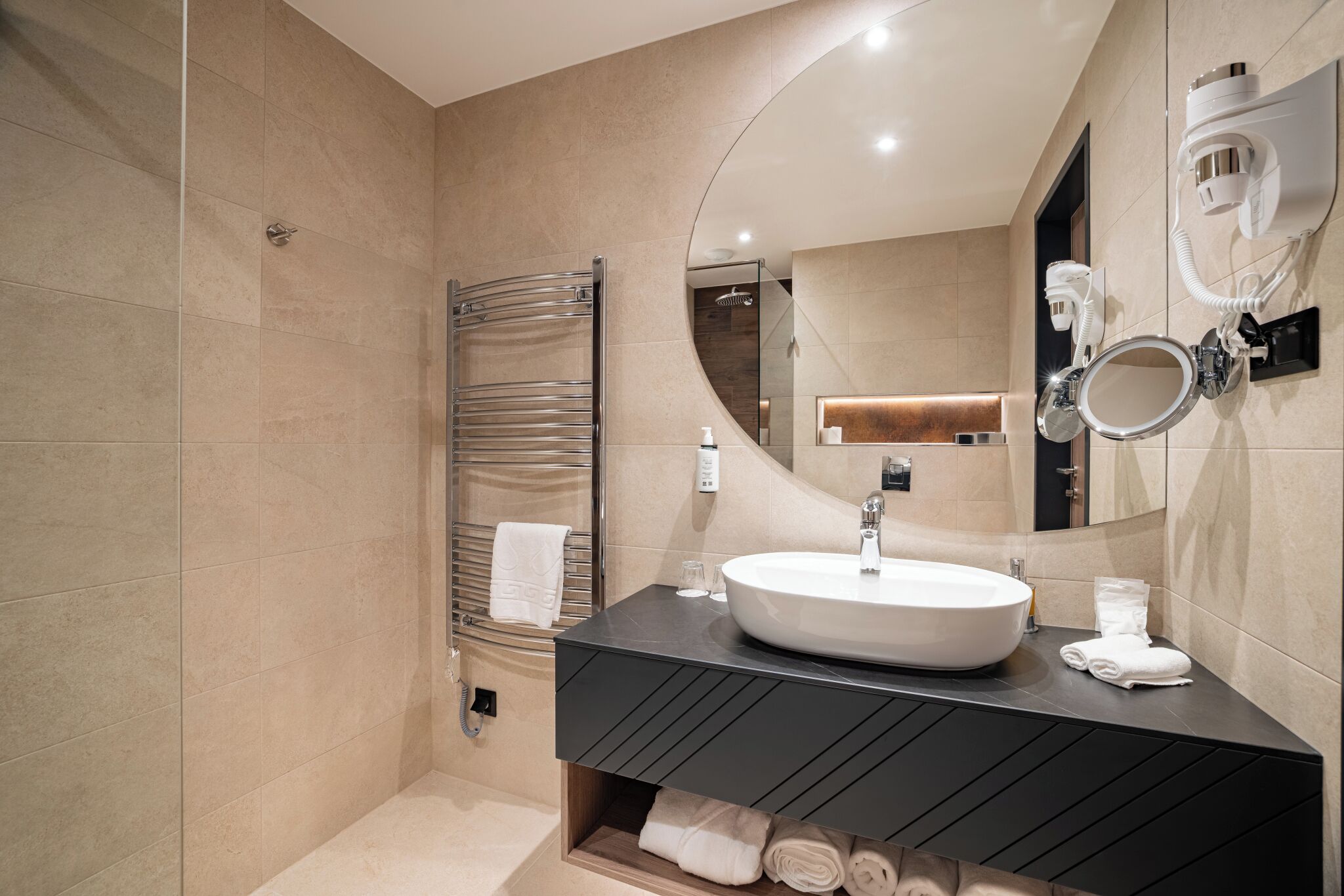 Un baño moderno con un lavamanos grande, un perchero y una ducha.