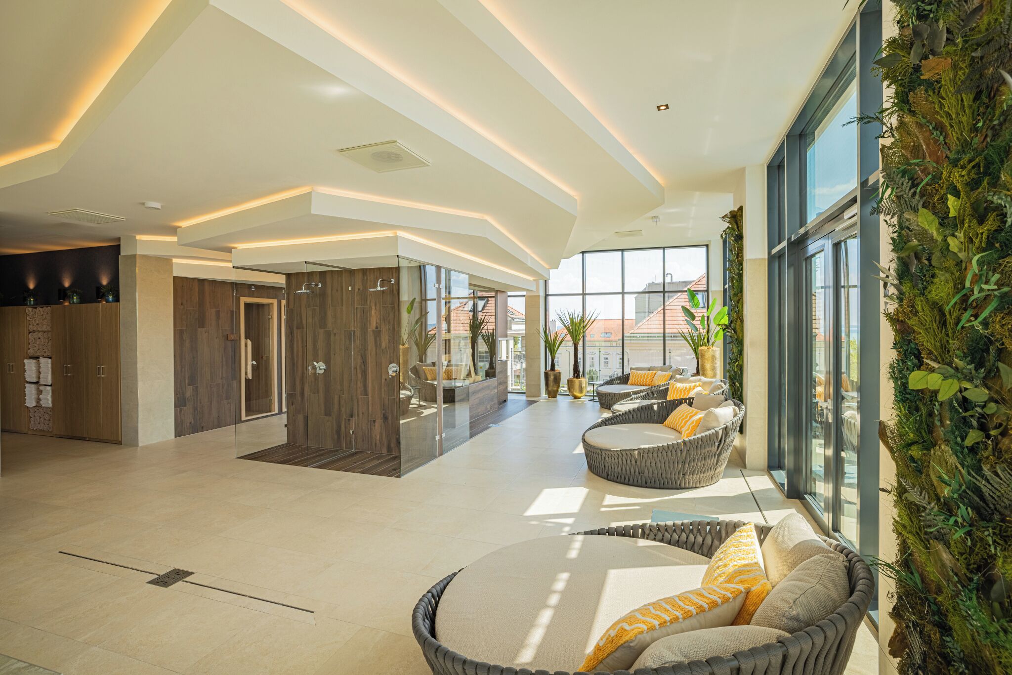 A spacious lobby with a high ceiling, large windows, and a seating area with wicker furniture.
