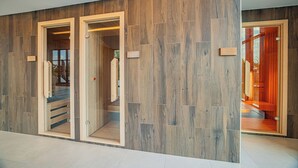 A hallway with wooden paneling and glass doors leading to a sauna area. - Montello Hotel (Balatonfüred)