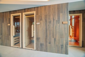 A hallway with wooden paneling and glass doors leading to a sauna area.