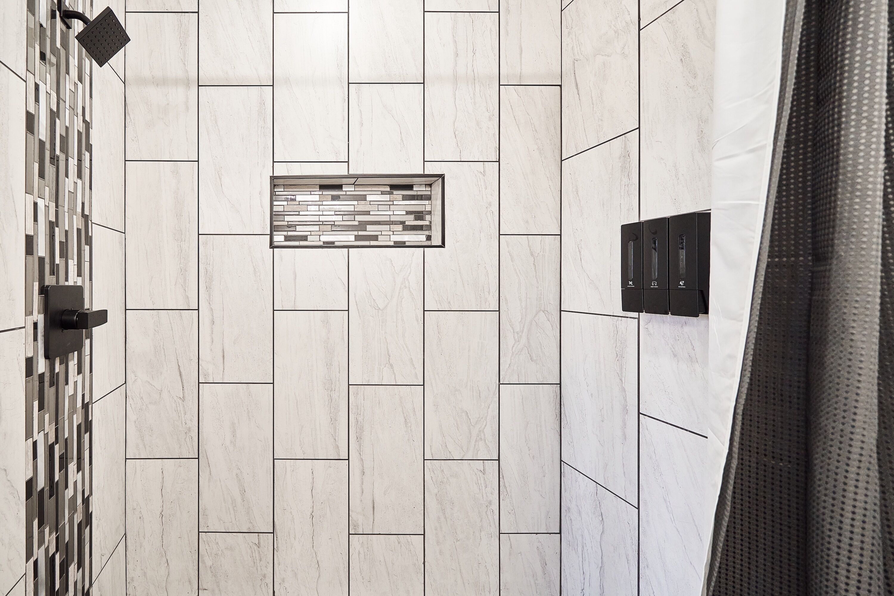 A tiled wall with a geometric pattern and a rectangular inset panel.