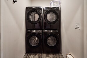 A laundry room with two stacked front-loading washing machines.