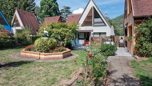 Un quartier résidentiel avec des maisons, un jardin fleuri et un ciel dégagé.