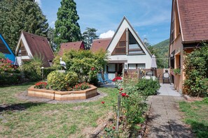 Un barrio residencial con casas, un jardín con flores y un cielo despejado.