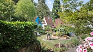 A residential area with houses, a garden with a bench, and a stone wall.