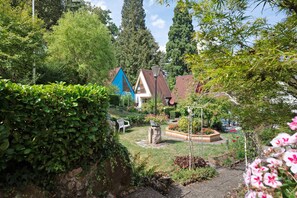 A residential area with houses, a garden with a bench, and a stone wall.