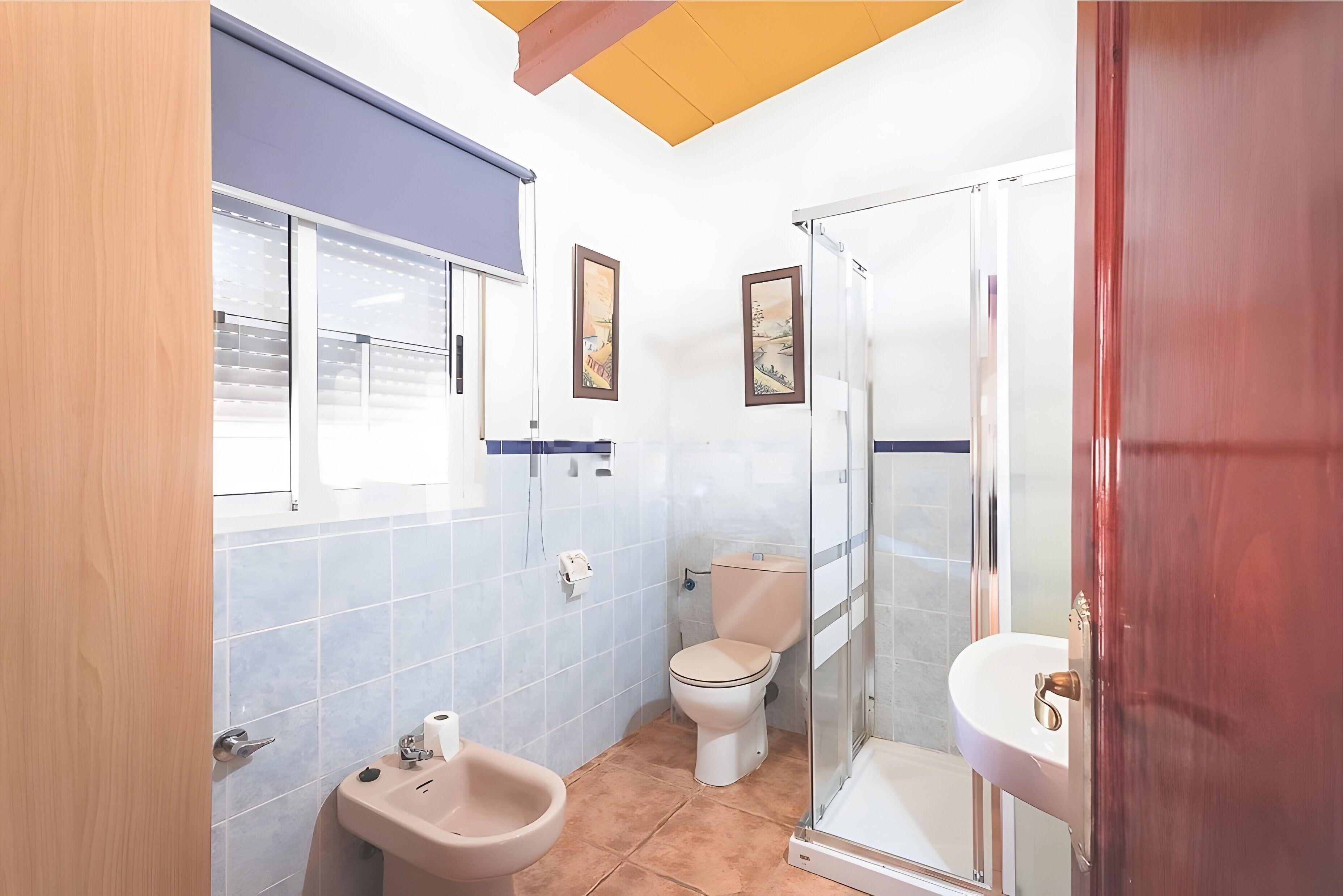Een badkamer met toilet, bidet en wastafel.