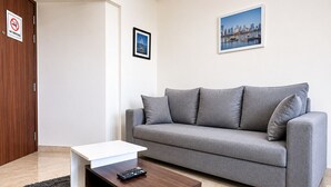 Una sala de estar moderna con un sofá gris, una mesa de centro y un cuadro en la pared.