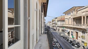 Una stretta via fiancheggiata da edifici, con una passeggiata pedonale e scooter parcheggiati.