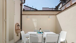 A patio with a table and chairs, a wall-mounted sink, and a window with a view of buildings. - Holiday Home 'Villa Lucia' with Sea View, Wi-Fi & Air Conditioning (Viareggio)
