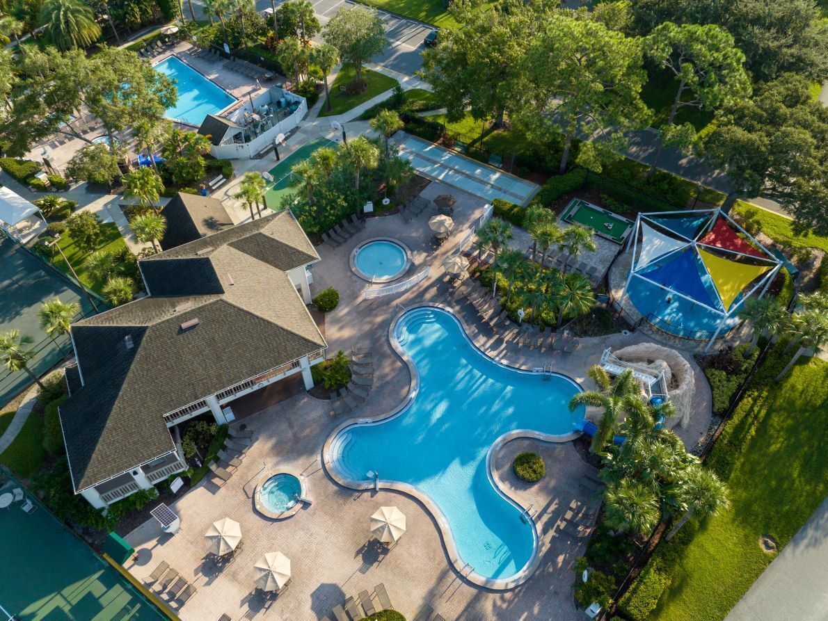 Un resort con varias piscinas, zonas de estar al aire libre y abundante vegetación.