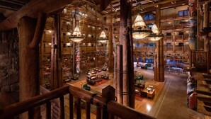 A spacious lobby with wooden architecture, multiple seating areas, and hanging light fixtures.