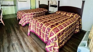 Una habitación con dos camas, un escritorio y una silla.