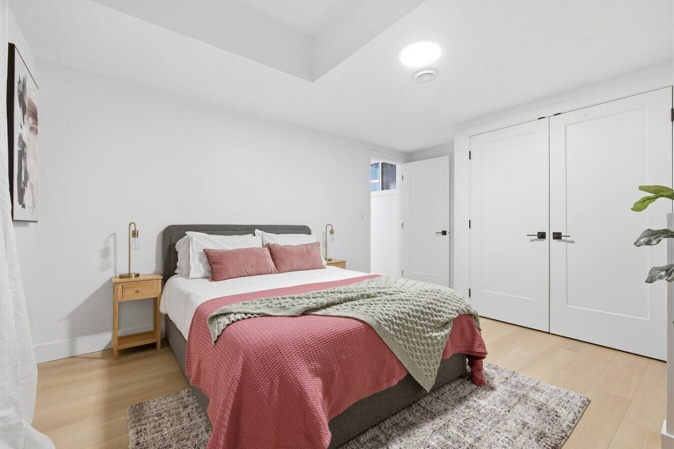 A bedroom with a bed, bedside tables, a wardrobe, and a ceiling light.