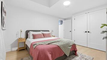 A bedroom with a bed, bedside tables, a wardrobe, and a ceiling light.