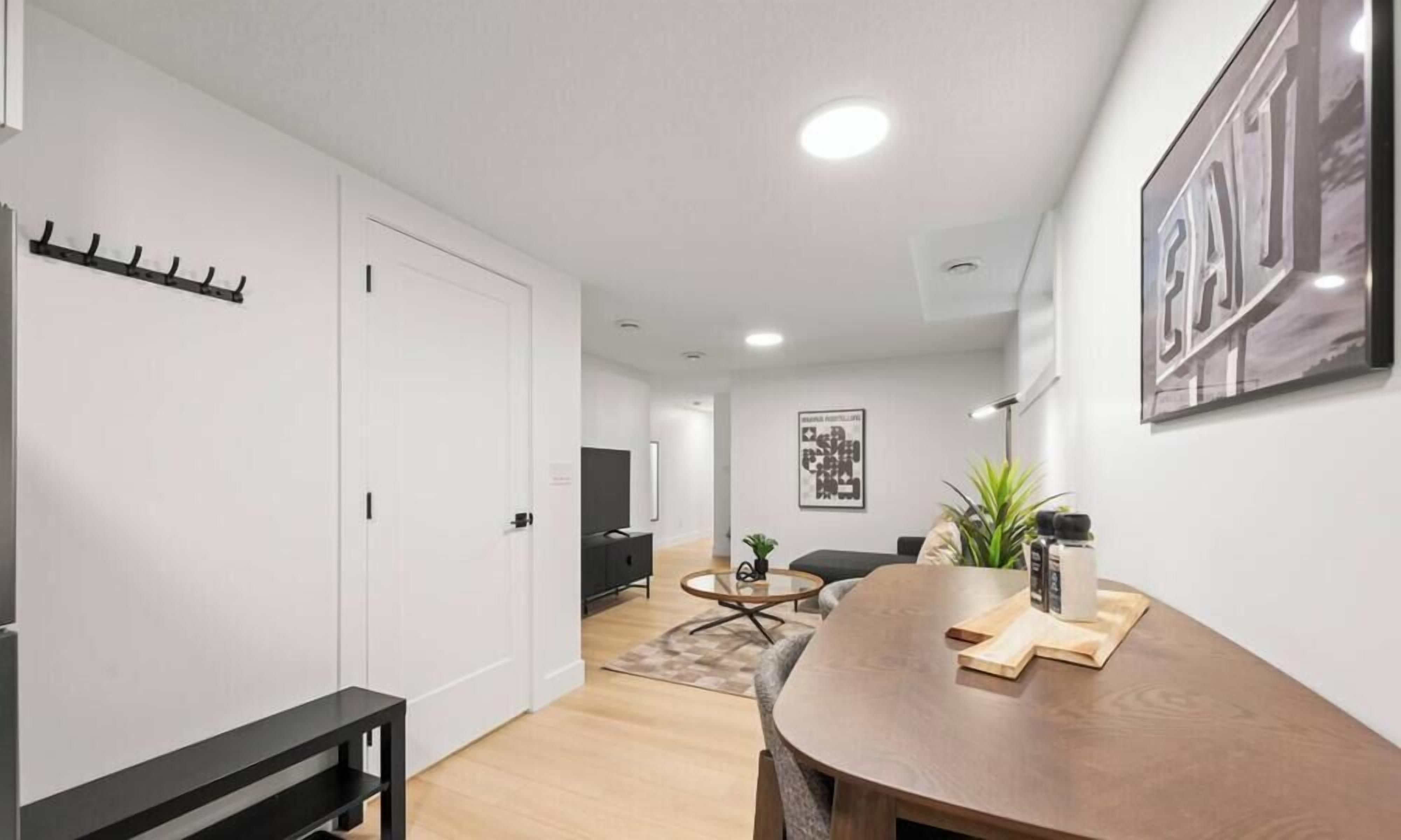 A modern living room with a dining area, a sofa, a coffee table, and a TV.