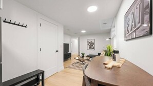 Una sala de estar moderna con comedor, un sofá, una mesa de centro y un televisor.