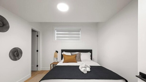 Un dormitorio moderno con una cama, un ventanal con persianas, un ventilador de pared y una puerta.