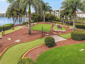 A landscaped outdoor area with a water feature, palm trees, and a walking path. - Family-Friendly 2 Bedroom Villa at Marriott Doral (, Miami)