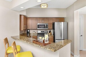 A kitchen with granite countertops, stainless steel appliances, and wooden cabinets. - Family-Friendly 2 Bedroom Villa at Marriott Doral (, Miami)