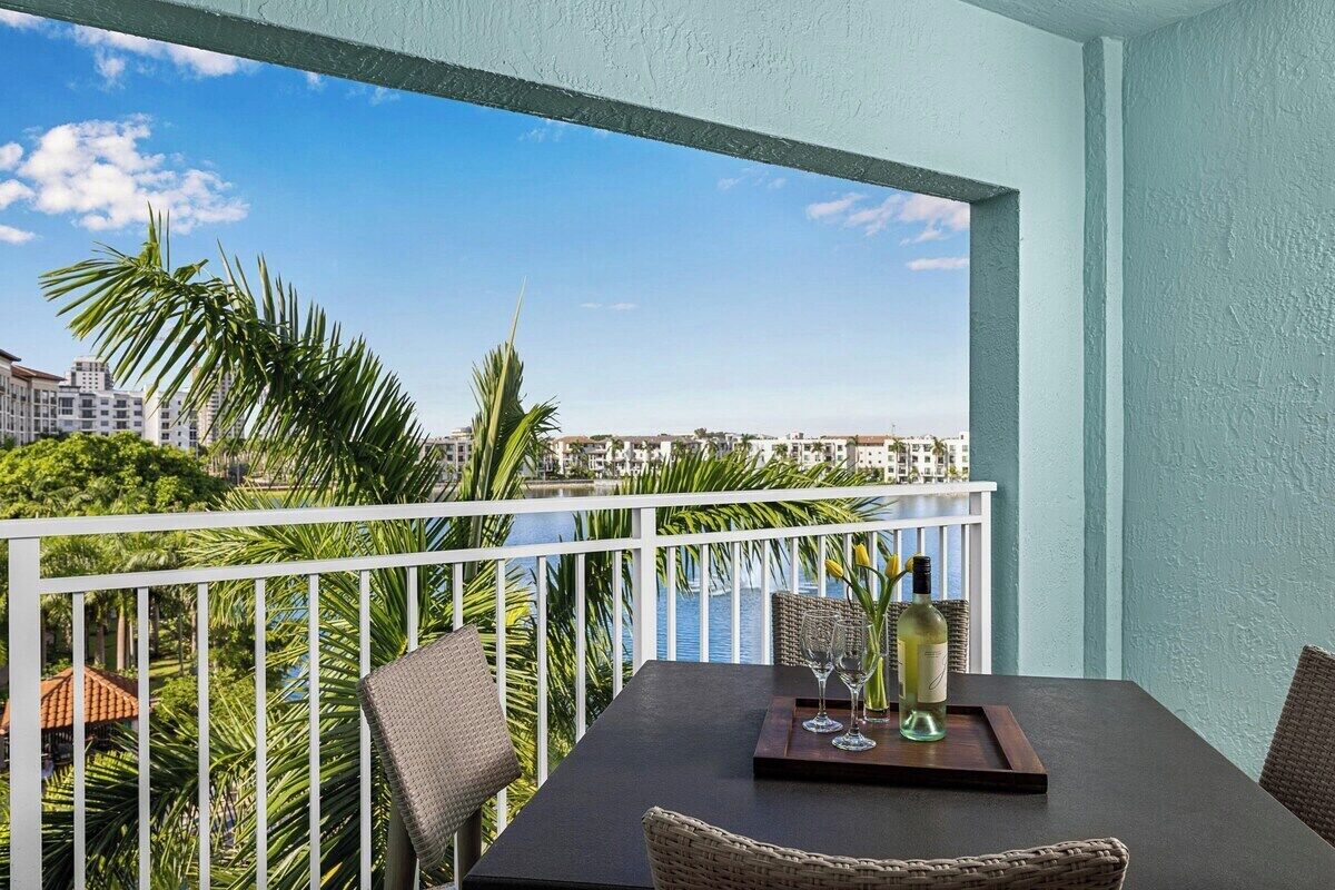 Ein Balkon mit Esstisch, mit Blick auf ein Gewässer und die Stadtlandschaft.