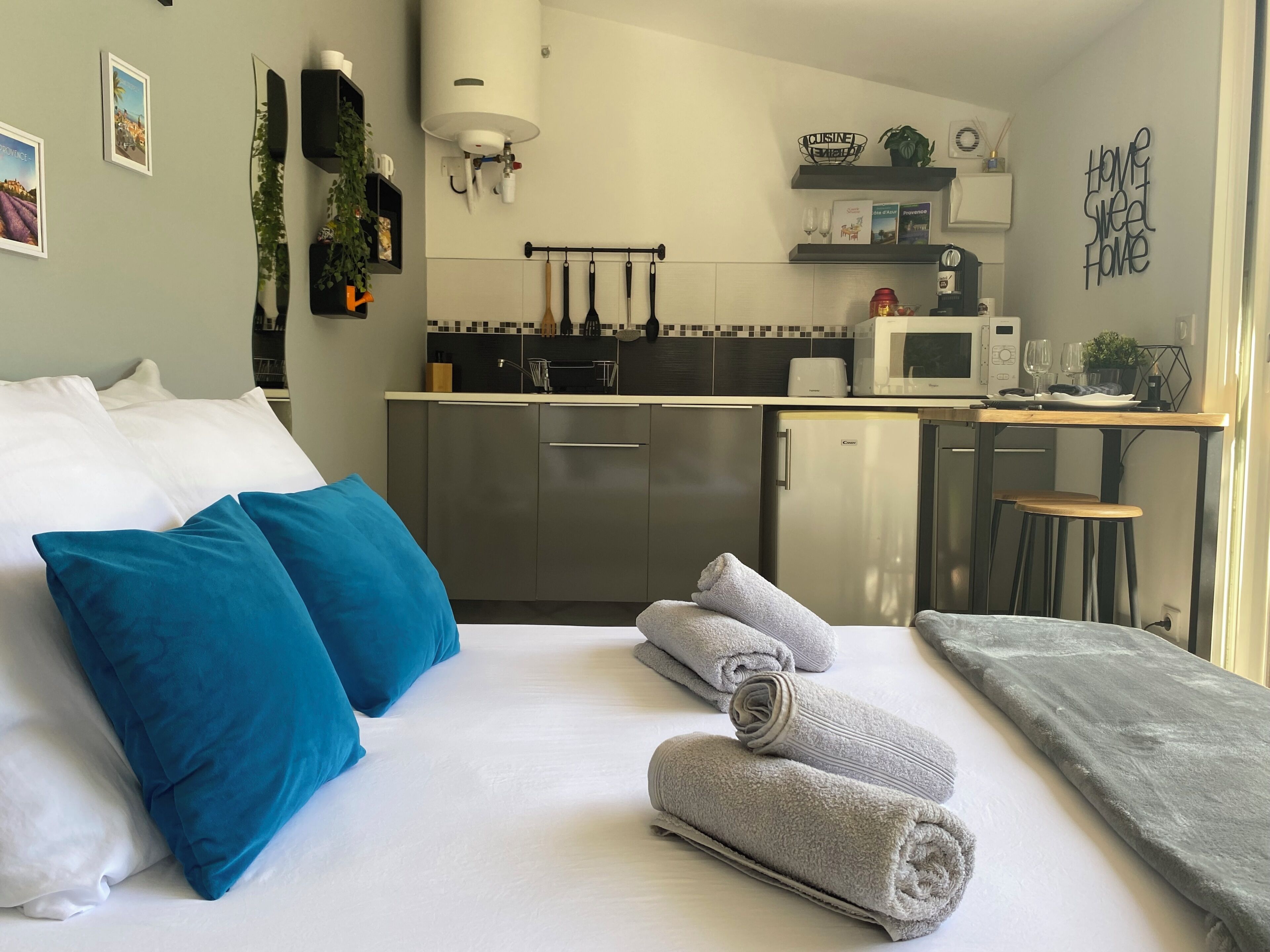 Una camera d'albergo moderna con un letto, un angolo cottura e vista sulla città.