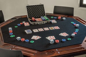 A poker table with chips and cards, a briefcase, and a window in the background.