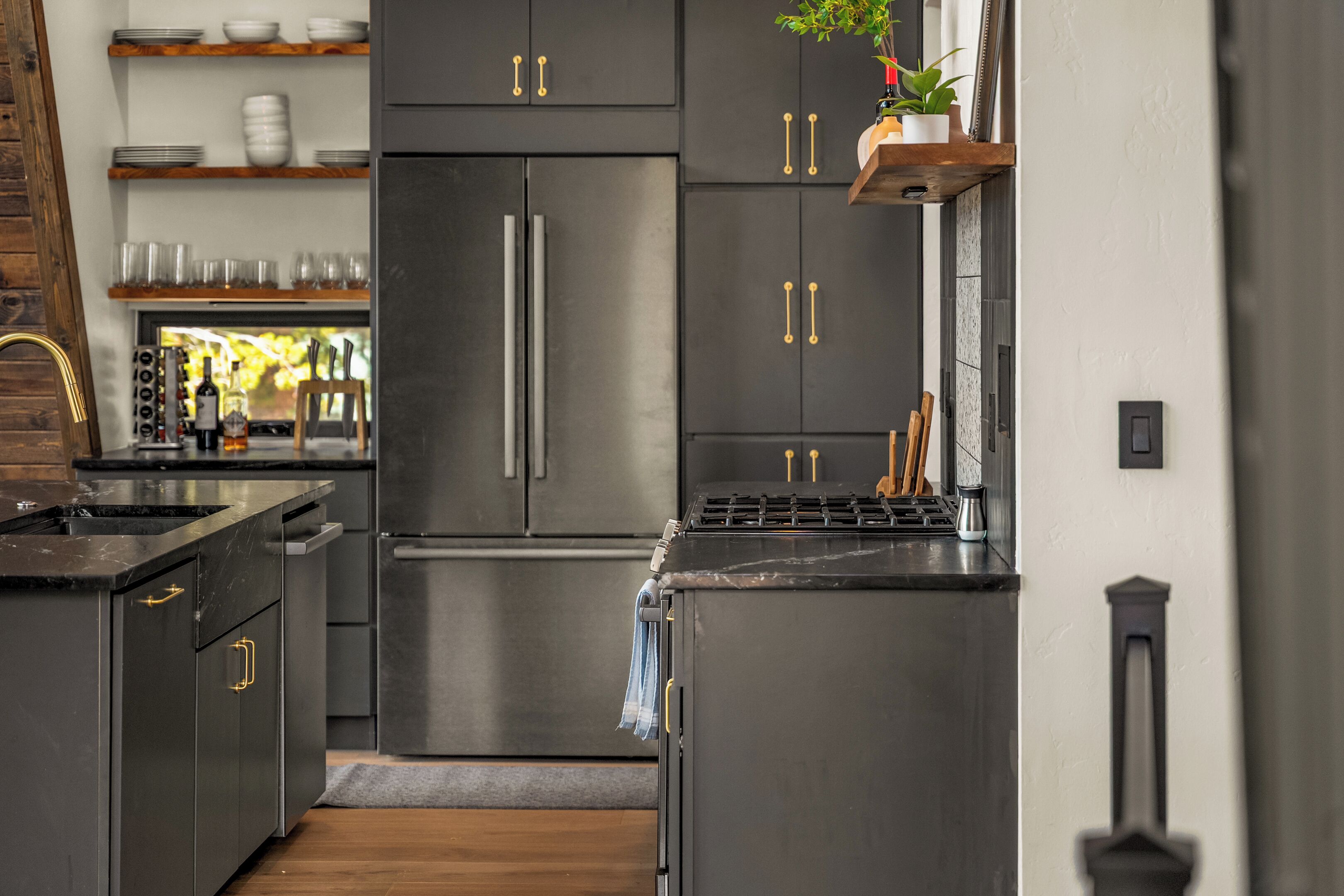 A modern kitchen with stainless steel appliances, wooden cabinets, and a built-in wine rack.
