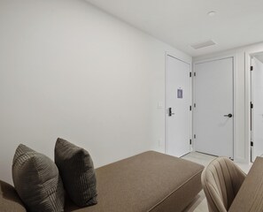 Ein Zimmer mit einer Couch, zwei Kissen und zwei geschlossenen Türen.