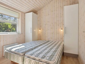A bedroom with two beds, a window, and wooden walls. - 4 Star Holiday Home in Albaek (Aalbaek)