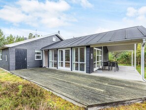 A modern house with a covered patio, large windows, and a deck. - 4 Star Holiday Home in Albaek (Aalbaek)