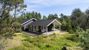 A modern house with a large deck, surrounded by dense forest. - 4 Star Holiday Home in Albaek (Aalbaek)