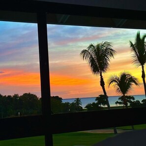 A sunset view through a window with palm trees and a distant body of water. - Luxury on the ocean, Teeth of the Dog Golf view (La Romana,)