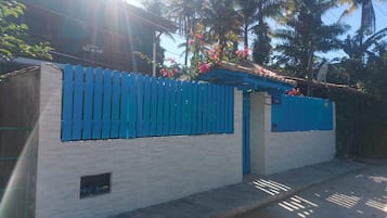 Un edificio con una cerca azul, una ventana pequeña y un cartel que indica una suite.