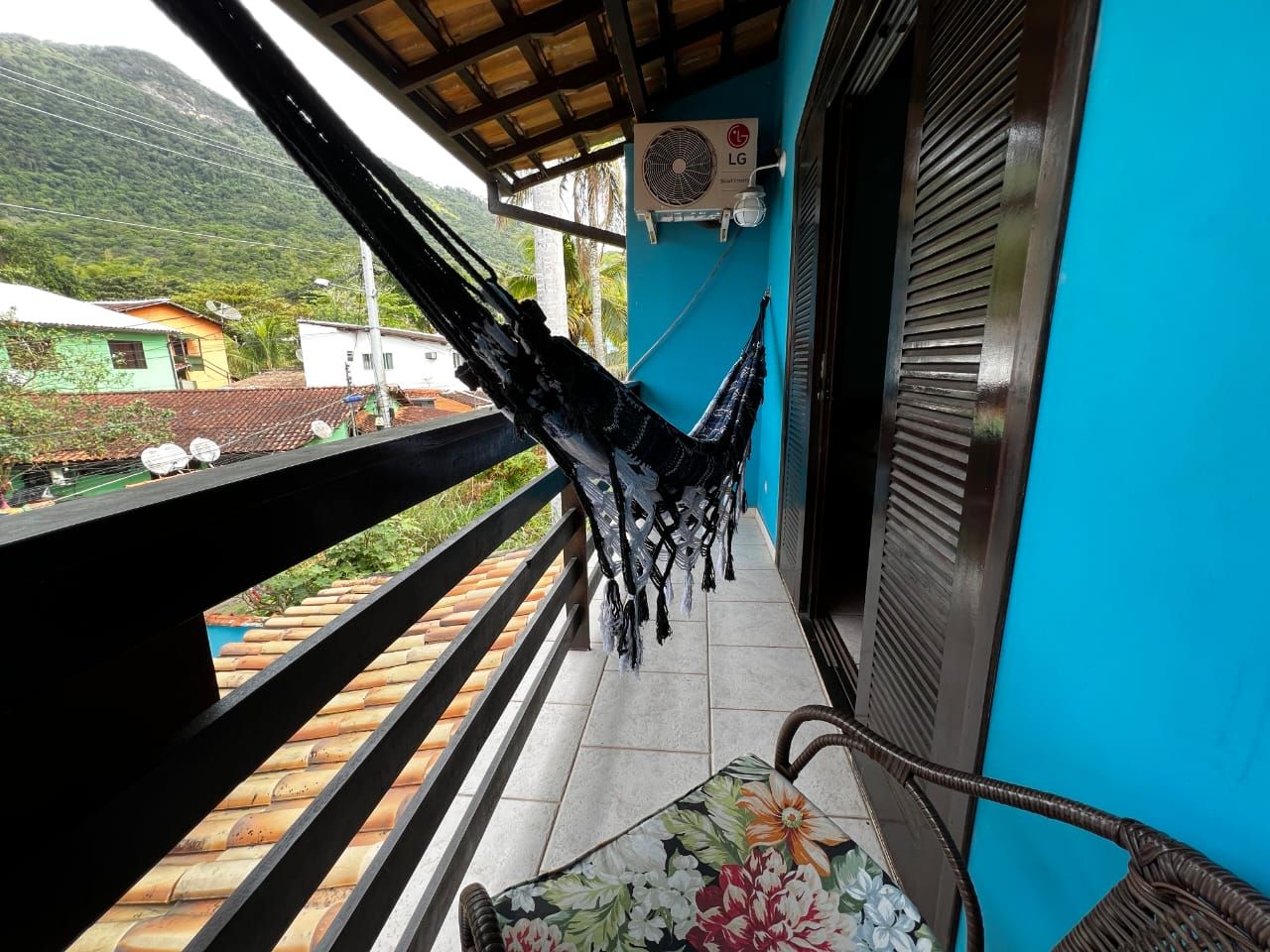 Un balcón con una hamaca, una silla y vistas a la montaña.
