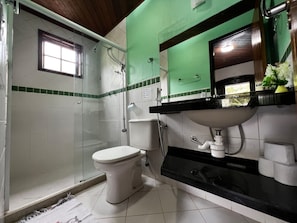 A bathroom with a toilet, shower, sink, and a window. - Azul del Mar (Ilha Grande)