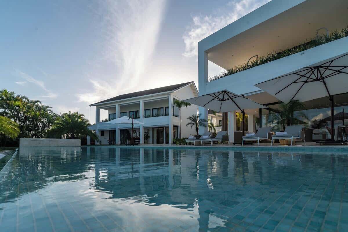 Ein modernes Hotel mit Pool, Außenbereich und einem zweistöckigen Gebäude.